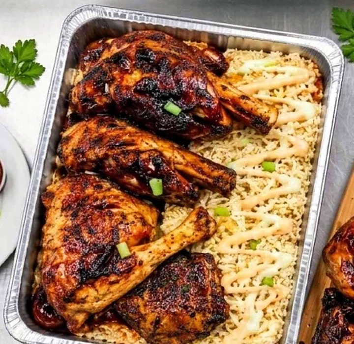 Smoked chicken quarters over rice in a tray