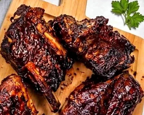 Glazed smoked beef ribs on a wooden board